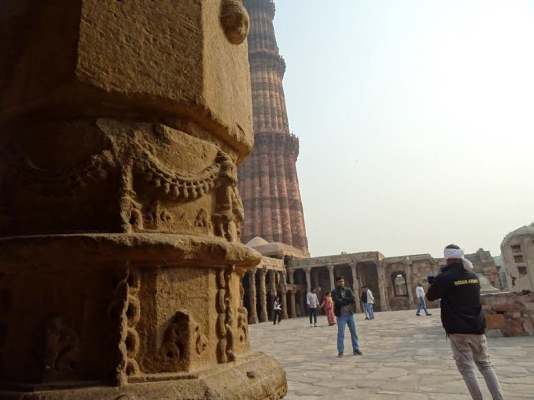 Das Bild zeigt die kunstvoll geschnitzten Wand des Qutb-Komplexes in Delhi, Indien. Der Bau des Turms begann 1199 n. Chr. und markierte den Beginn der muslimischen Herrschaft in Indien
