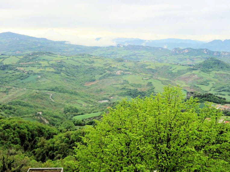 Das Bild zeigt einen Panoramablick auf die Landschaft vom Monte Titano in der Republik San Marino. Dieser Berg ist der h�chste Punkt des Landes und erreicht eine H�he von etwa 749 bis 756 Metern. Umgebende Landschaft: Der Blick schweift �ber die sanften H