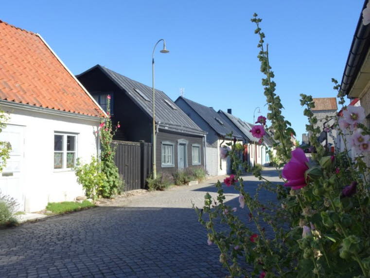Das Bild zeigt eine malerische Stra�e in Visby auf der schwedischen Insel Gotland. Diese historische Stadt geh�rt zum UNESCO-Weltkulturerbe und ist f�r ihre gut erhaltene mittelalterliche Stadtmauer sowie ihre charmanten Holzh�user bekannt.