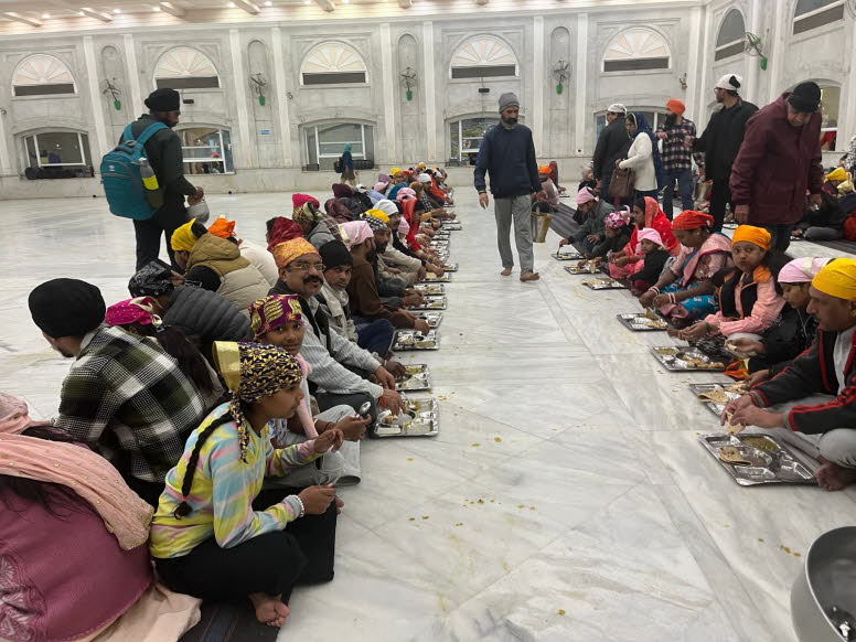 Das Bild zeigt Menschen, die im Langar, der Gemeinschaftsk�che des Gurdwara Bangla Sahib in Neu-Delhi, Indien, eine Mahlzeit einnehmen. Der Gurdwara Bangla Sahib ist ein bekanntes Gotteshaus der Sikh in Delhi. Der Langar bietet allen Besuchern, unabh�ngig