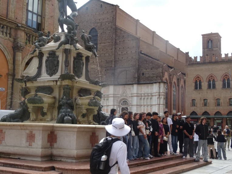 Architekturhistorische Einordnung: Das Foto zeigt einen der architekturhistorisch dichtesten Orte Bolognas: den Bereich um die Fontana del Nettuno vor dem Palazzo Re Enzo und dem Palazzo del Podest�. Diese Geb�ude bilden das politische und urbane Herz der