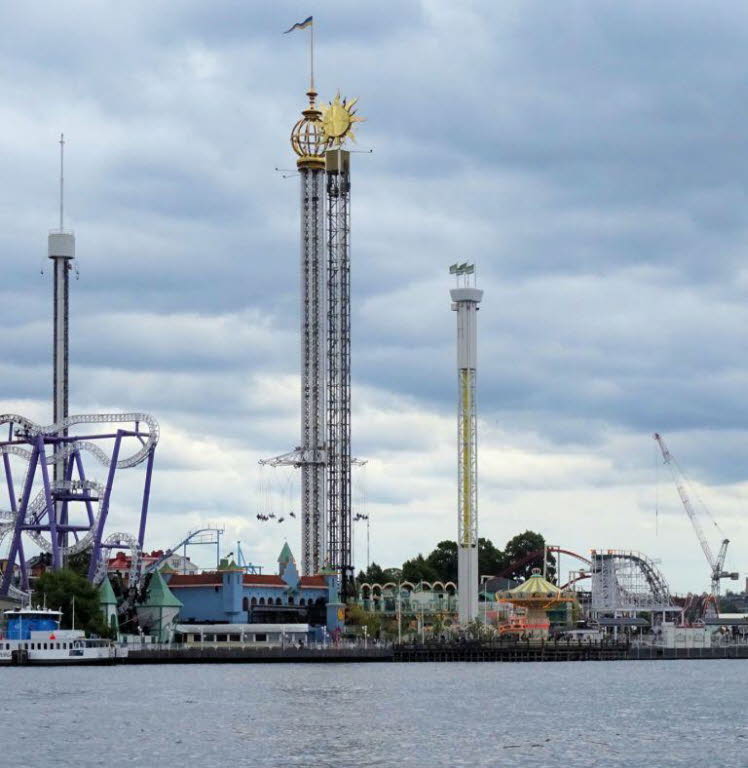 Das Bild zeigt den bekannten Vergn�gungspark Gr�na Lund auf der Insel Djurg�rden in Stockholm, Schweden. Die Aufnahme bietet einen Blick von der Wasserseite auf die ber�hmten Fahrgesch�fte und Attraktionen des Parks.