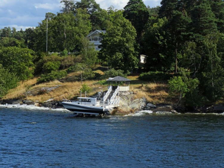 Das im markierten Bereich sichtbare Boot ist eine Paragon 31 Cabin (oder ein �hnliches Modell der Paragon-Serie), die auf einer speziellen Bootslift-Plattform direkt am felsigen Ufer ruht.