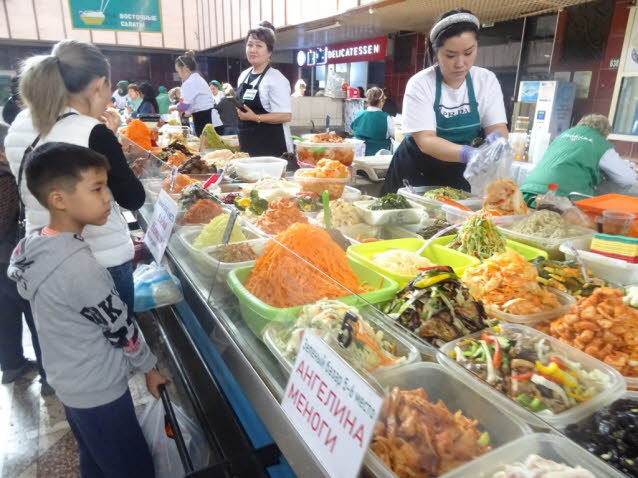 Basar in Almaty, Kasachstan mit Obst und Gemse. Angebote in russischer Sprache geschrieben.