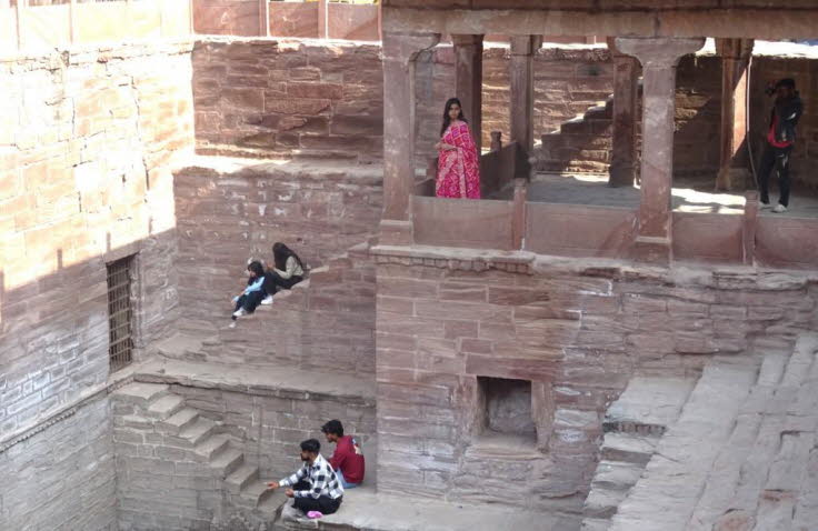 Das Bild zeigt den historischen Toorji Ka Jhalra (Toorji's Step Well oder Stufenbrunnen) in Jodhpur, Rajasthan, Indien. Details zur Szene: Architektur: Der Brunnen wurde im 18. Jahrhundert erbaut und verf�gt �ber kunstvolle handgeschnitzte W�nde aus rotem