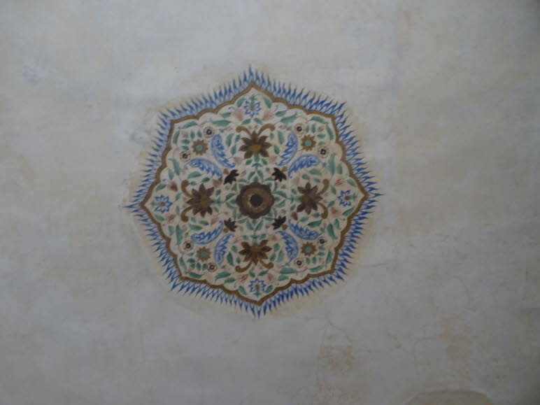 Bei dem Bild handelt es sich um eine Nahaufnahme einer kunstvollen floralen Decken- oder Wandmalerei, die typisch f�r die Architektur des Amber Forts in Jaipur, Indien, ist. Diese Art von Ornamentik ist ein wesentliches Merkmal der indo-islamischen Archit