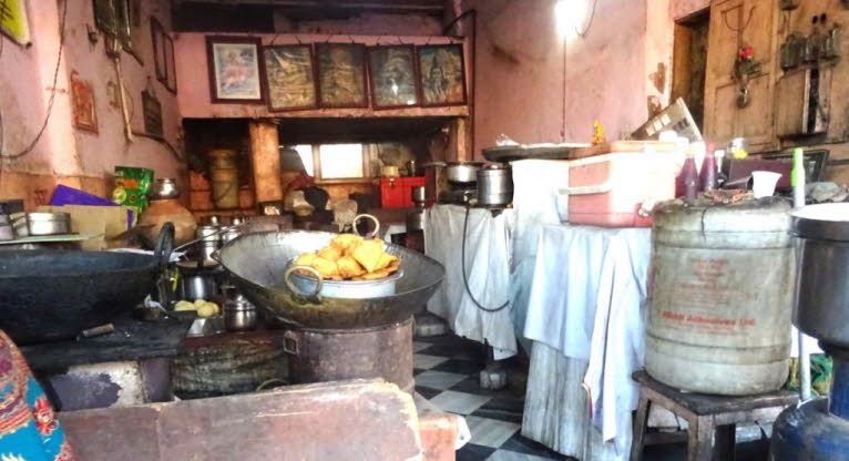 Das Bild zeigt das Innere eines kleinen, traditionellen Imbisses oder einer K�che, wahrscheinlich in S�dasienin Jaipur.