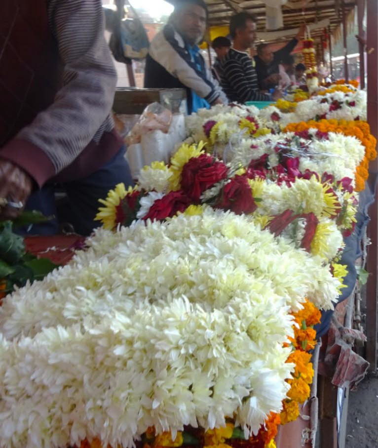 Dies ist ein gesch�ftiger Blumenmarkt in Jaipur, auf dem Verk�ufer traditionelle Blumengirlanden, sogenannte Malas oder Varamalas, herstellen und verkaufen. Diese M�rkte sind oft lebendige Zentren des t�glichen Lebens. Marktdetails: Produkte: Im Vordergru