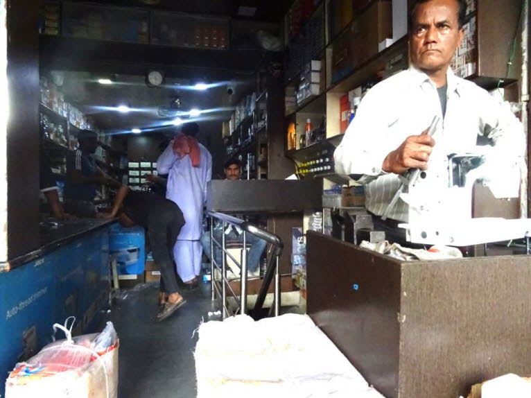 Dieser Mann betreibt einen kleinen, mobilen Reparaturservice auf der Stra�e in Jaipur. Details zur Szene:  Standort und T�tigkeit: Der Mann arbeitet im Freien. Ausr�stung: Er verwendet eine robuste, industrielle N�hmaschine (�hnlich den Marken Singer oder