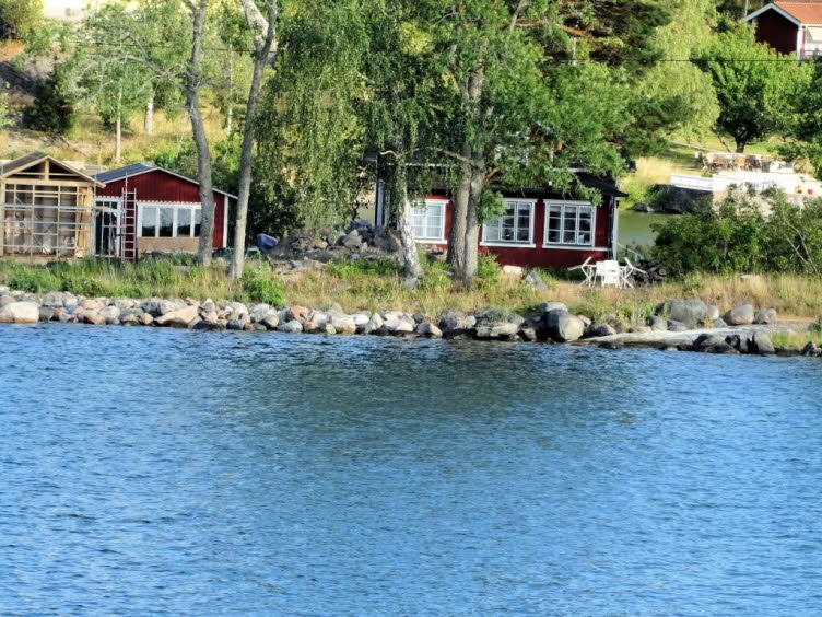 Das Bild zeigt eine klassische skandinavische Sommerhaus-Idylle direkt an der felsigen K�ste