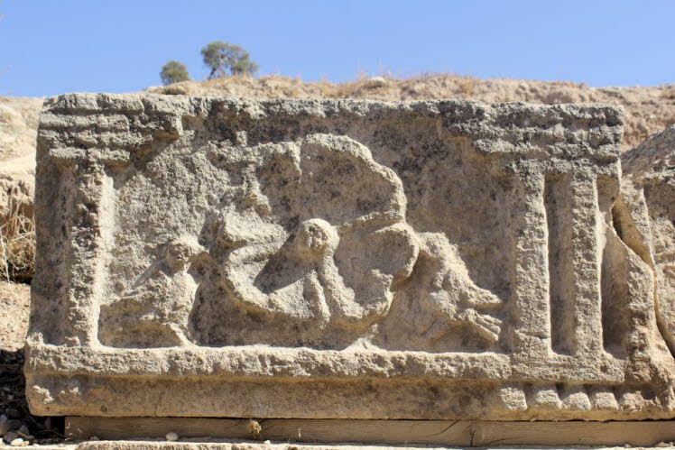 Das Bild zeigt ein altes Steinrelief, das m�glicherweise eine mythologische oder religi�se Szene darstellt. Das Relief ist stark verwittert, aber es scheint drei Figuren zu zeigen. Es k�nnte sich um eine Darstellung einer Gottheit mit Verehrern oder einer