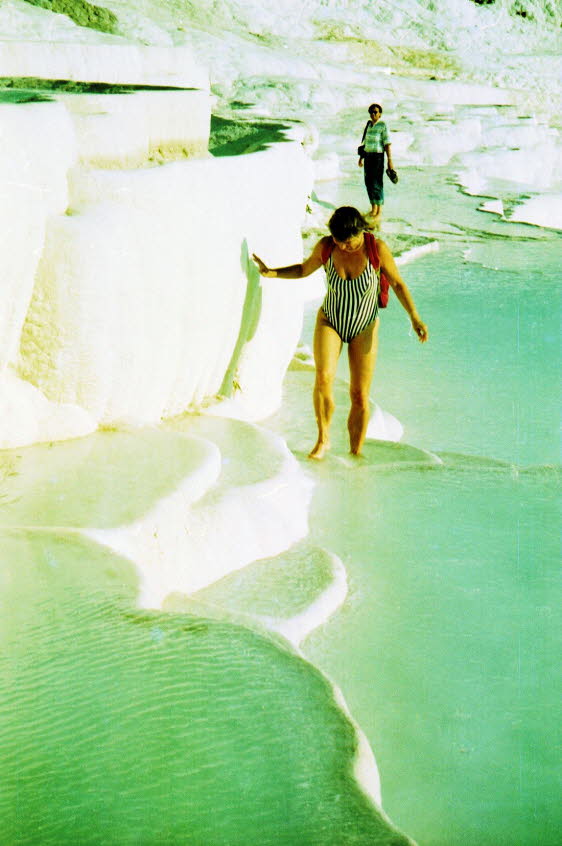 Das kalkhaltige Wasser, das aus Quellen in einer fast 200 m hohen Klippe mit Blick auf die Ebene entspringt, hat in Pamukkale (Baumwollpalast) eine unwirkliche Landschaft geschaffen, die aus Mineralwldern, versteinerten Wasserfllen und einer Reihe terra