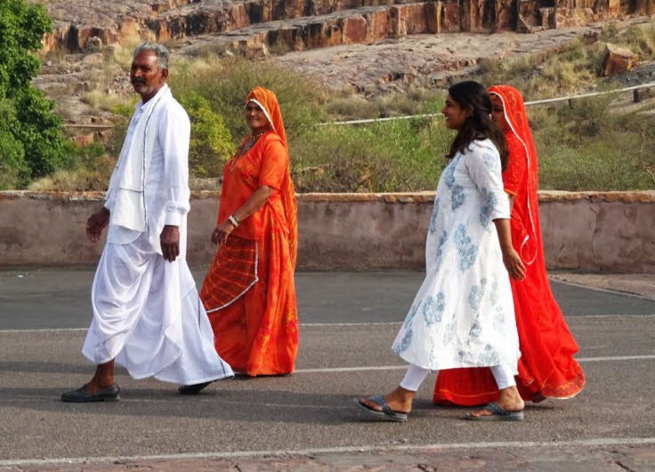 Die abgebildeten Frauen tragen traditionelle indische Kleidung, die in Regionen wie Rajasthan, wo Jodhpur liegt, �blich ist. Kleidung: Die Frauen tragen farbenfrohe Outfits, darunter Sarees oder Salwar Kameez, mit Dupattas (Schals) �ber dem Kopf oder den 