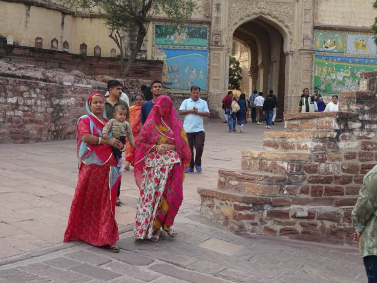 Die Frauen tragen traditionelle indische Kleidung, insbesondere Saris oder �hnliche Gew�nder in leuchtenden Farben wie Rot und Pink, was typisch f�r die Region Rajasthan ist.